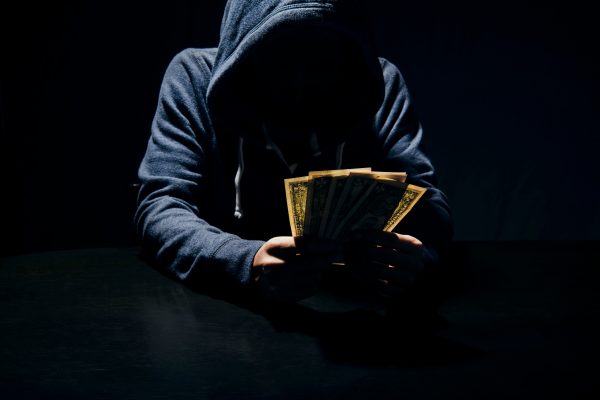 Businessman giving bribe banknote money crypto scam in dark